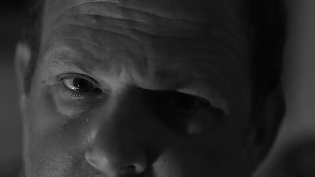 Extreme close-up of a man's eye in hard black-and-white light.